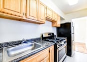 Thumbnail 3 of 22 - kitchen with wood cabinetry, tile flooring and window at the richman apartments in washington dc