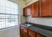 Thumbnail 2 of 29 - kitchen with large window, oak cabinetry and tile backsplash at the frontenac apartments in van ness washington dc