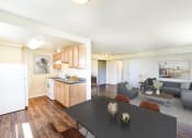 Thumbnail 5 of 18 - a living room with a black dining table and a kitchen at 734 longfellow tax credit apartments in washington dc