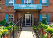Thumbnail 1 of 15 - exterior of brick apartment building at manor village tax credit apartments in washington dc