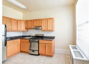 Thumbnail 9 of 28 - kitchen with stainless steel appliances, wood cabinetry and large window at norwood apartments in washington dc