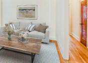 Thumbnail 5 of 26 - living area with sofa, coffee table, hardwood floors, large windows and ceiling fan  at 2800 ontario road apartments in washington dc