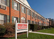 Thumbnail 13 of 17 - A red brick building with a sign that says The Strathmore Apartment Apartments.