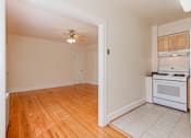 Thumbnail 13 of 29 - kitchen with wood cabinetry, gas range and view of living area at parkside apartments in washington dc
