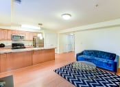 Thumbnail 6 of 20 - living area with sofa, coffee table and view of large open kitchen at park vista apartments in washington dc