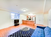 Thumbnail 9 of 20 - living area with sofa, credenza, tv, coffee table, window, and view of large open kitchen at park vista apartments in washington dc