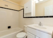 Thumbnail 10 of 13 - bathroom with tub, toilet, mirror, sink, medicine cabinet and tile details at penn view apartments in washington dc