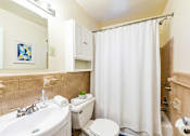 Thumbnail 22 of 22 - A bathroom with a white shower curtain and a white toilet.