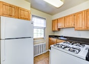 Thumbnail 8 of 22 - kitchen with wood cabinetry, tile flooring and window at the richman apartments in washington dc