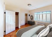 Thumbnail 10 of 20 - Bedroom with bed, nightstands, large windows, and large closet at sherry Hall apartments in washington dc