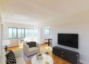 Thumbnail 4 of 20 - living area with sofa, coffee table, hardwood floors, credenza with tv, and large windows at sherry hall apartments in washington dc