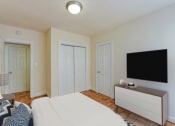 Thumbnail 6 of 20 - Bedroom with bed, dresser, tv, and large closet at sherry Hall apartments in washintgon dc