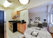 Thumbnail 3 of 20 - kitchen with wood cabinetry, gas range, stainless steel appliances, and view of living area at sherry hall apartments in washington dc