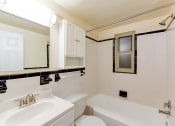 Thumbnail 7 of 20 - bathroom with tub, vanity, large mirror and tile details at sherry hall apartments in washington dc