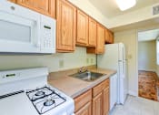 Thumbnail 8 of 21 - kitchen with gas range, refrigerator and view of dining area at shipley park apartments in shipley terrace washington dc