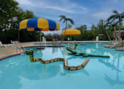 Thumbnail 22 of 25 - A pool with a blue and yellow umbrella and a green inflatable.
