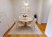 Thumbnail 5 of 17 - A white dining room with a round table and chairs.