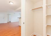 Thumbnail 5 of 15 - hallway view of large closet with shelving and living area with wood flooring at t street apartments in washington dc