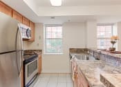 Thumbnail 4 of 14 - kitchen with stainless steel appliances, window and breakfast bar at the oaks apartments in washington dc