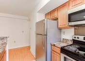 Thumbnail 5 of 14 - kitchen with stainless steel appliances and wood cabinets at the oaks apartments in washington dc