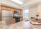 Thumbnail 2 of 14 - kitchen with stainless steel appliances and breakfast bar at the oaks apartments in washington dc
