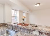 Thumbnail 3 of 14 - kitchen with breakfast bar and view of dining area at the oaks apartments in washington dc