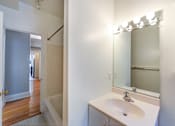 Thumbnail 10 of 21 - bathroom with vanity, mirror, tub and view of hallway at the shawmut apartments in adams morgan washington dc