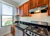 Thumbnail 1 of 21 - kitchen with stainless steel appliances, wood cabinetry and large window at the shawmut apartments in washington dc
