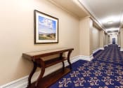 Thumbnail 12 of 25 - hallway with a bench and a painting on the wall at the calverton apartments in washington dc