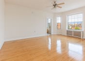Thumbnail 16 of 25 - an empty living room with hardwood floors and a ceiling fan at the calverton apartment building in washington dc