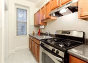 Thumbnail 3 of 25 - a kitchen with a stove top oven next to a window at the calverton apartments in washington dc