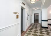 Thumbnail 63 of 64 - A hallway with a checkered floor and a sign that says "ELEVENOR".