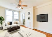 Thumbnail 10 of 22 - studio apartment showing sofa, bed, ceiling fan, large windows and view of kitchen at the foreland apartments in washinton dc