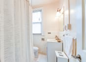 Thumbnail 11 of 22 - bathroom with toilet, tub, vanity and mirror at the foreland apartments in washington dc