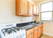 Thumbnail 3 of 22 - kitchen with gas range, wood cabinetry and energy efficient appliances at the foreland apartments in washinton dc