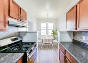 Thumbnail 3 of 29 - kitchen with stainless steel appliances, modern countertops and view of dining area at the frontenac apartments in washington dc