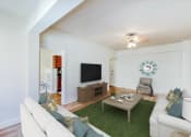 Thumbnail 6 of 29 - living area with sofa, coffee table, credenza, tv, ceiling fan and view of kitchen at frontenac apartments in washington dc.