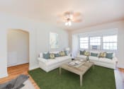 Thumbnail 5 of 29 - living area with sofa, coffee table, hardwood floors, ceiling fan and large windows at frontenac apartments in washington dc.