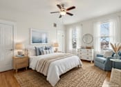 Thumbnail 21 of 36 - A bedroom with a large bed, a ceiling fan, and a view of the ocean through a window.