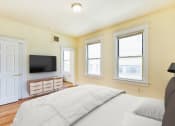 Thumbnail 8 of 39 - Bedroom with bed, dresser, tv, and large windows  at twin oaks apartments columbia heights washington dc