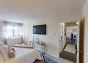 Thumbnail 11 of 27 - Bedroom with dresser, tv, bed and large windows at washington view apartments in southeast dc