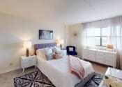 Thumbnail 13 of 27 - Bedroom with nightstands, bed and large windows at washington view apartments in southeast dc