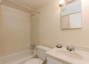 Thumbnail 22 of 27 - bathroom with mirror, tub, toilet and vanity at washington view apartments in southeast dc