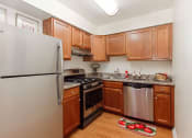 Thumbnail 15 of 27 - renovated kitchen with stainless steel appliances and hardwood flooring at washington view apartments in southeast dc