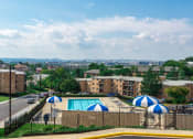 Thumbnail 1 of 27 - view of pool with chaise lounge chairs and umbrellas at washington view apartments in south east dc