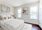 Thumbnail 8 of 14 - bedroom with bed, hardwood flooring and large windows at sheridan station south townhomes in washington dc