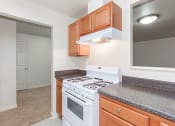 Thumbnail 6 of 17 - kitchen with gas range, wood cabinetry and energy efficient appliances at whitelaw apartments in washington dc