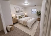Thumbnail 5 of 21 - A bedroom with a large bed, two lamps, and a plant.