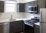 Thumbnail 29 of 29 - A kitchen with a stove, sink, and refrigerator.