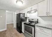 Thumbnail 39 of 52 - Renovated kitchen with white cabinets and black appliances at Pines at Lawrenceville Decatur 30033